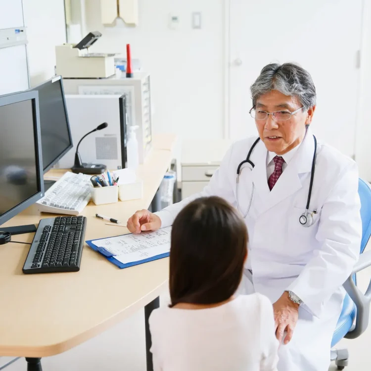 Physician at computer speaking with patient